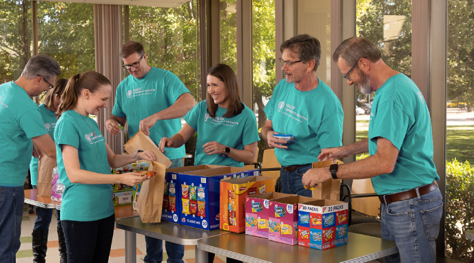 Group of HCI volunteers at a packing event demonstrataing Halff's value of Sharing